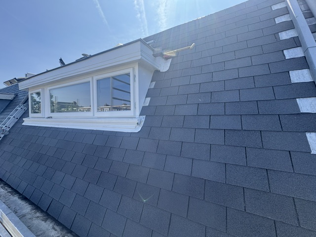 Dakkapel met grijze shingles en witte kozijnen