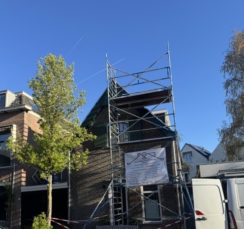 Woning met steiger en het bedrijfsbanner van JH-loodgietersonderhoudbedrijf